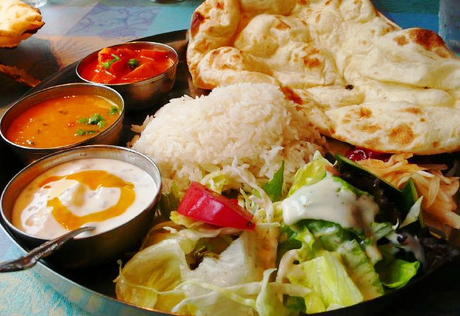 curries, rice, salad, and naan bread